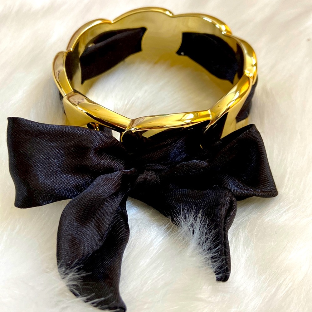 Cute goldtone bracelet with black ribbon.